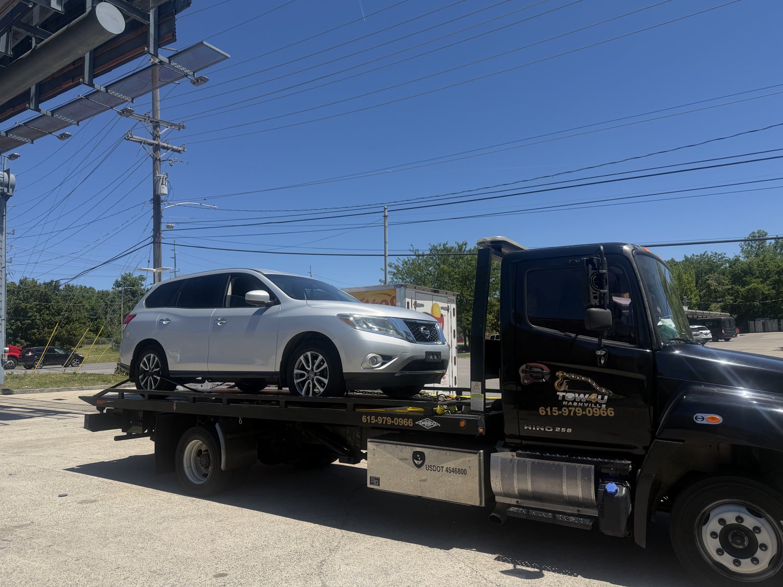 TOW4U Hino 258 flatbed transporting a silver Nissan Pathfinder in Nashville TN